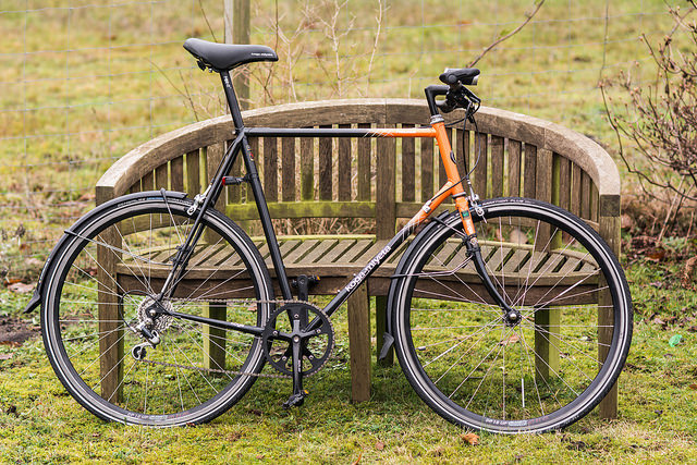 Ein fahrrad, dass an einer Parkbank angelehnt ist.